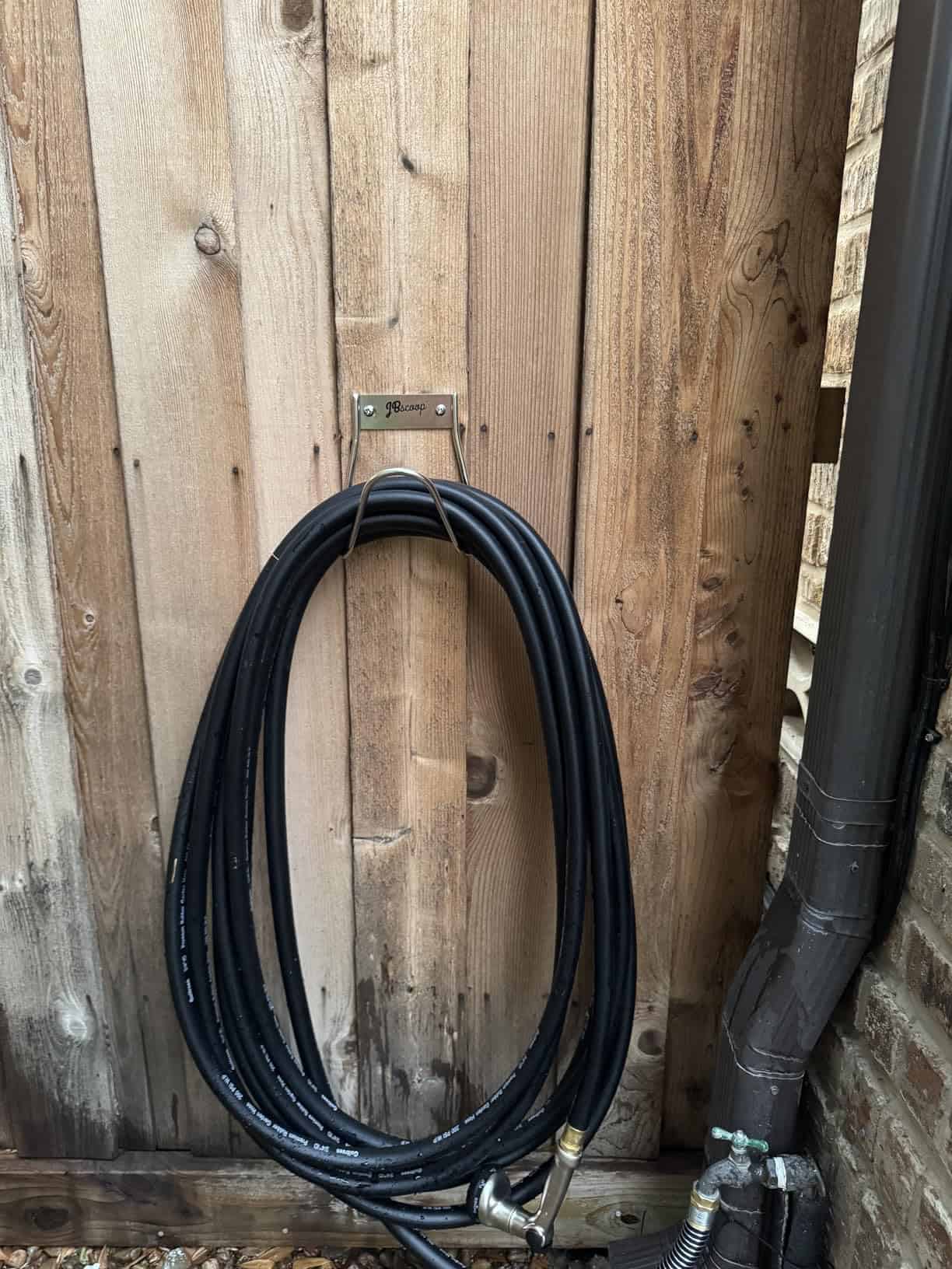 Garden hose rack mounted on a wall for outdoor use mounted a=on wooden wall