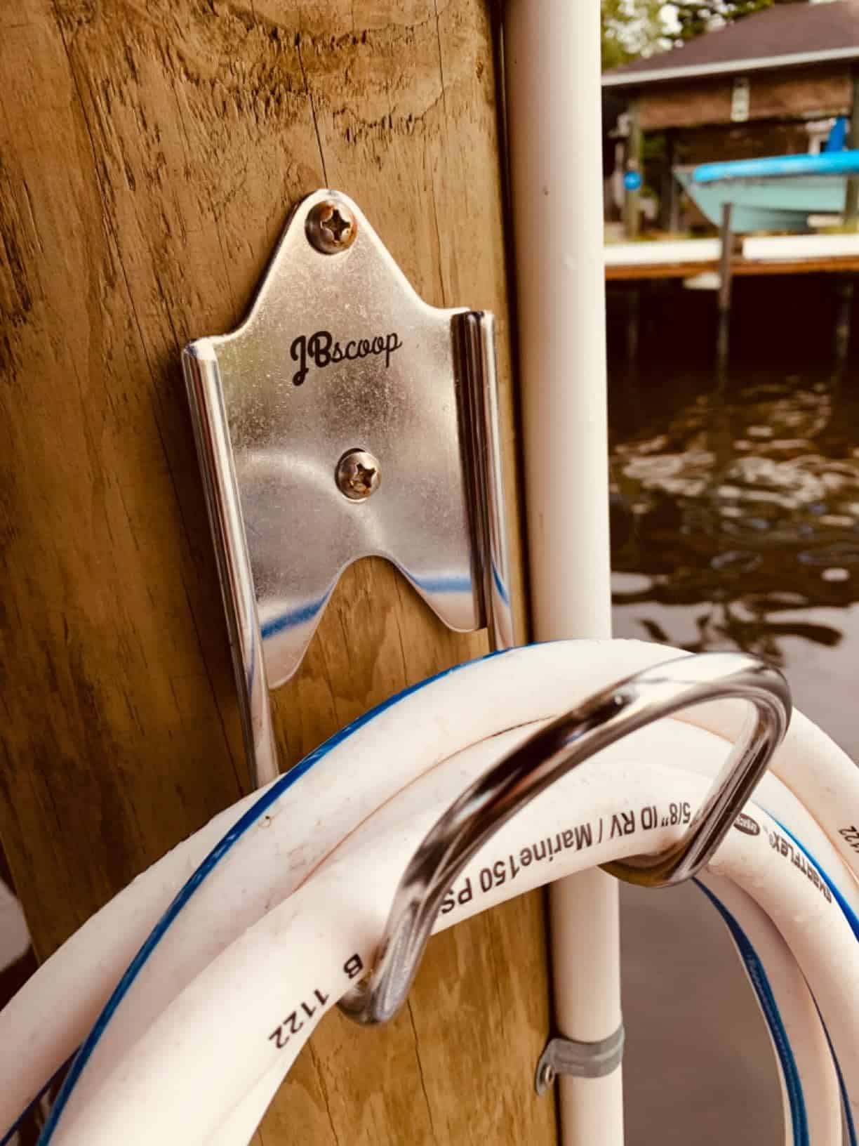 Garden hose hanger attached to an exterior wall